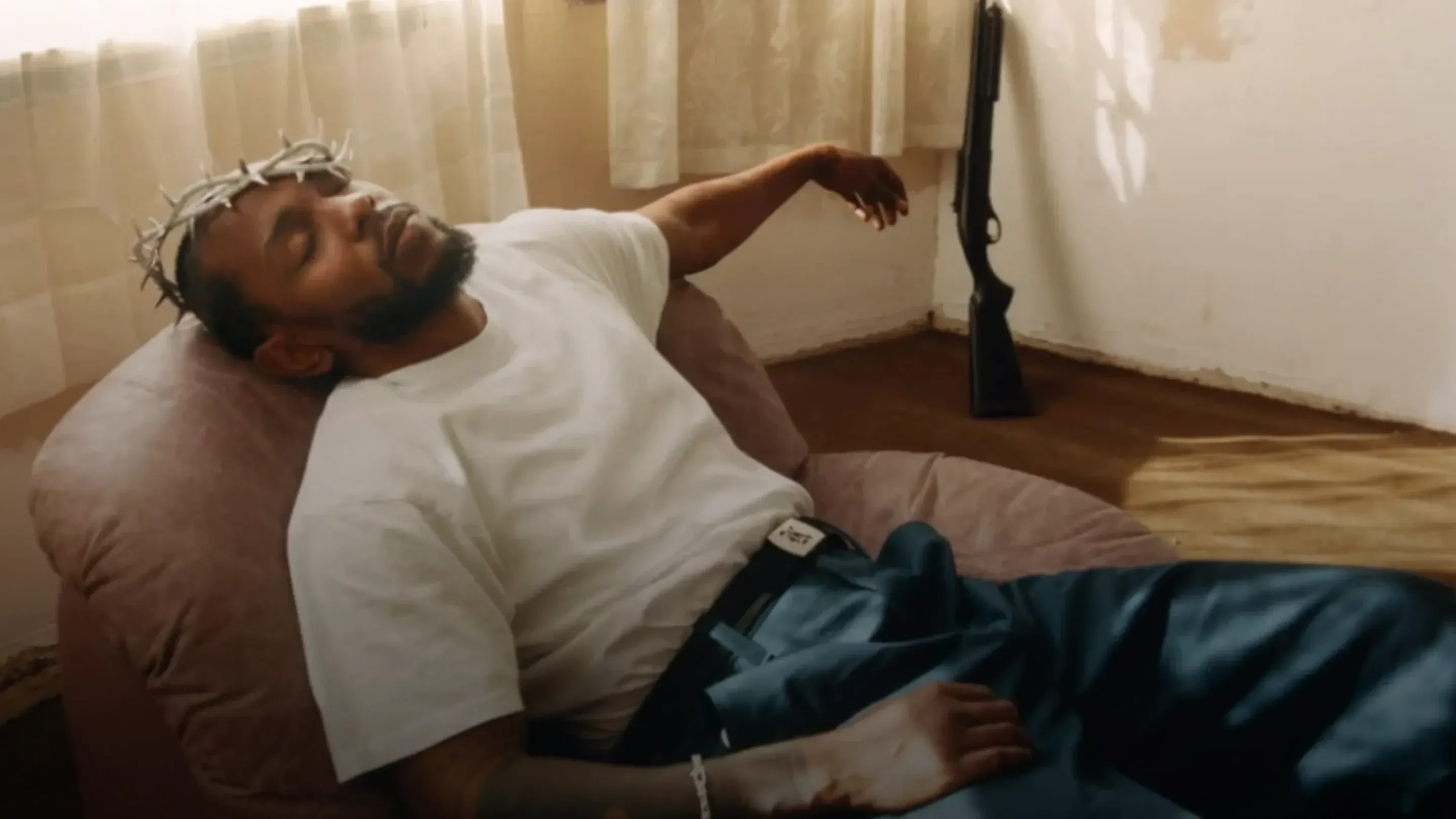 Kendrick Lamar reclining in a white Pro Club t-shirt