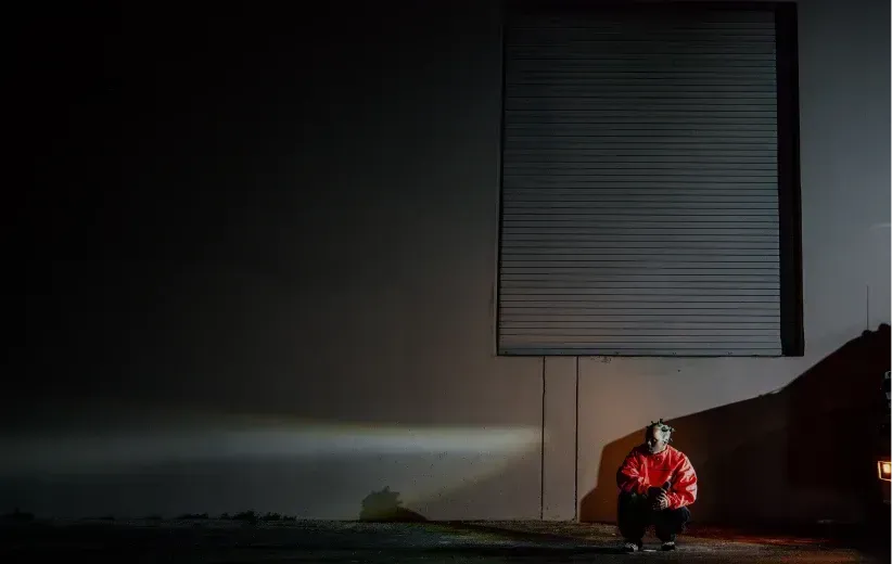 Artist crouched at night for the Mark Lux capsule launch