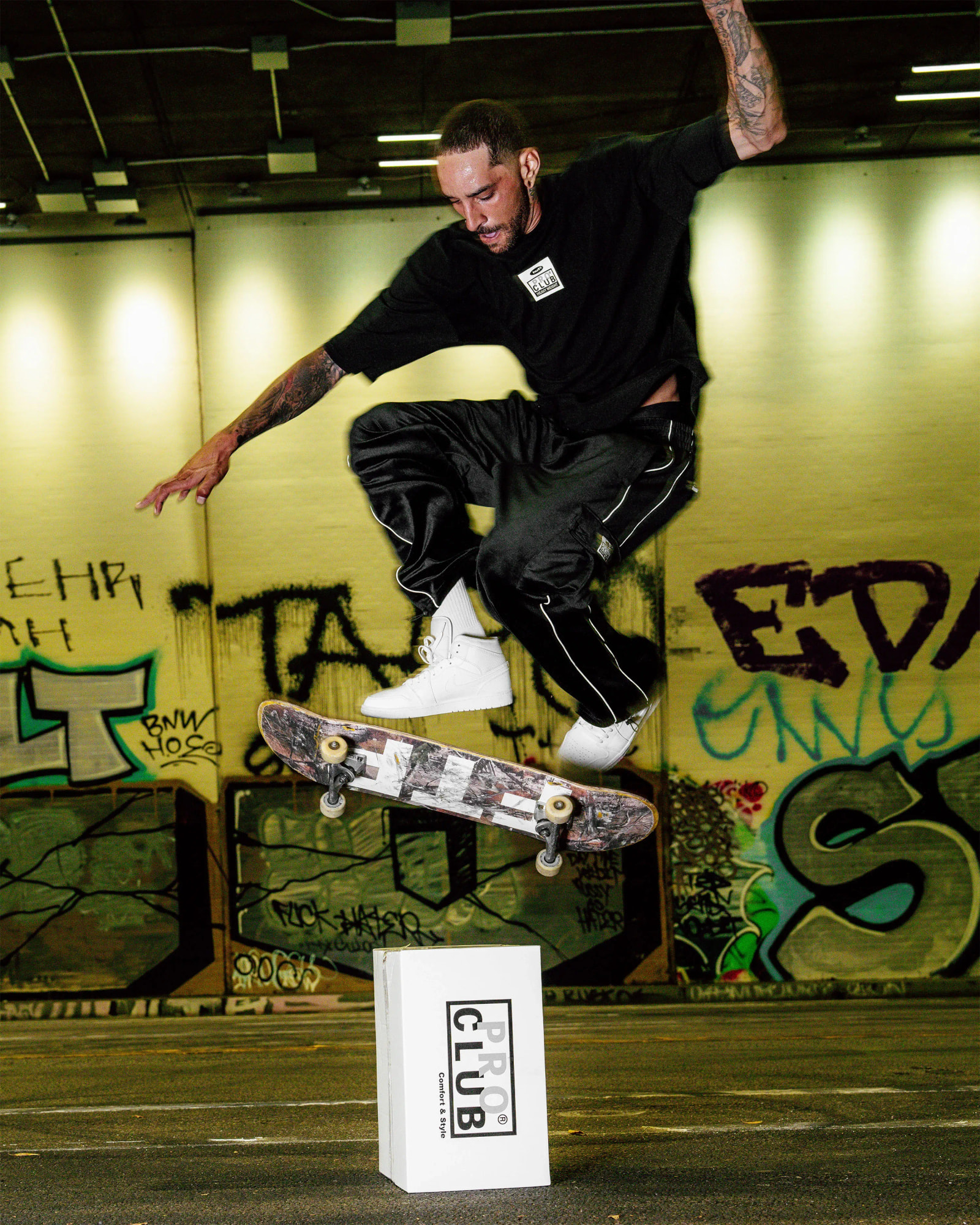 men in proclub X HUF tee & pant doing skates on proclub box