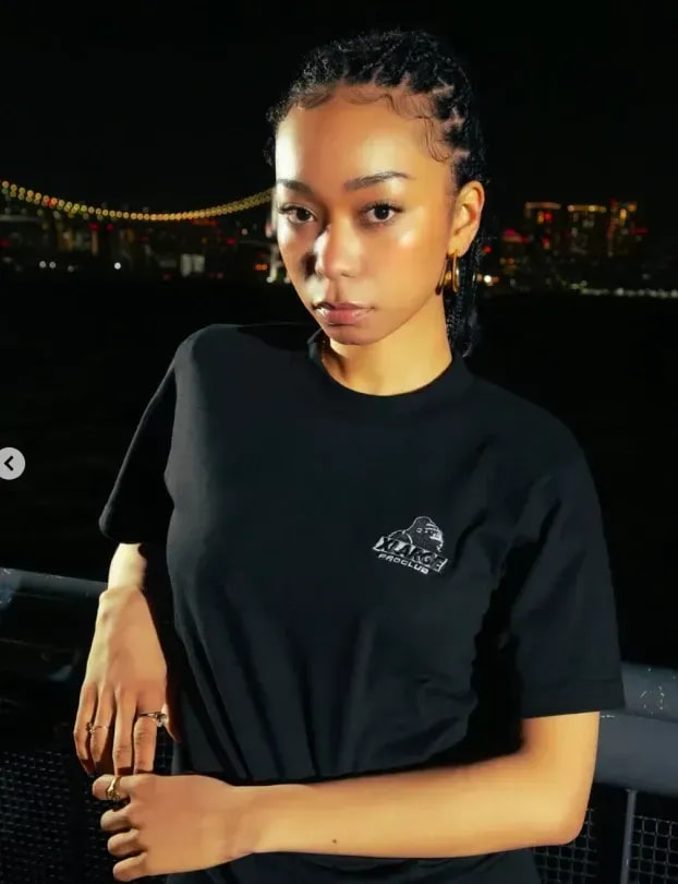 Woman by the waterfront with a city skyline at night