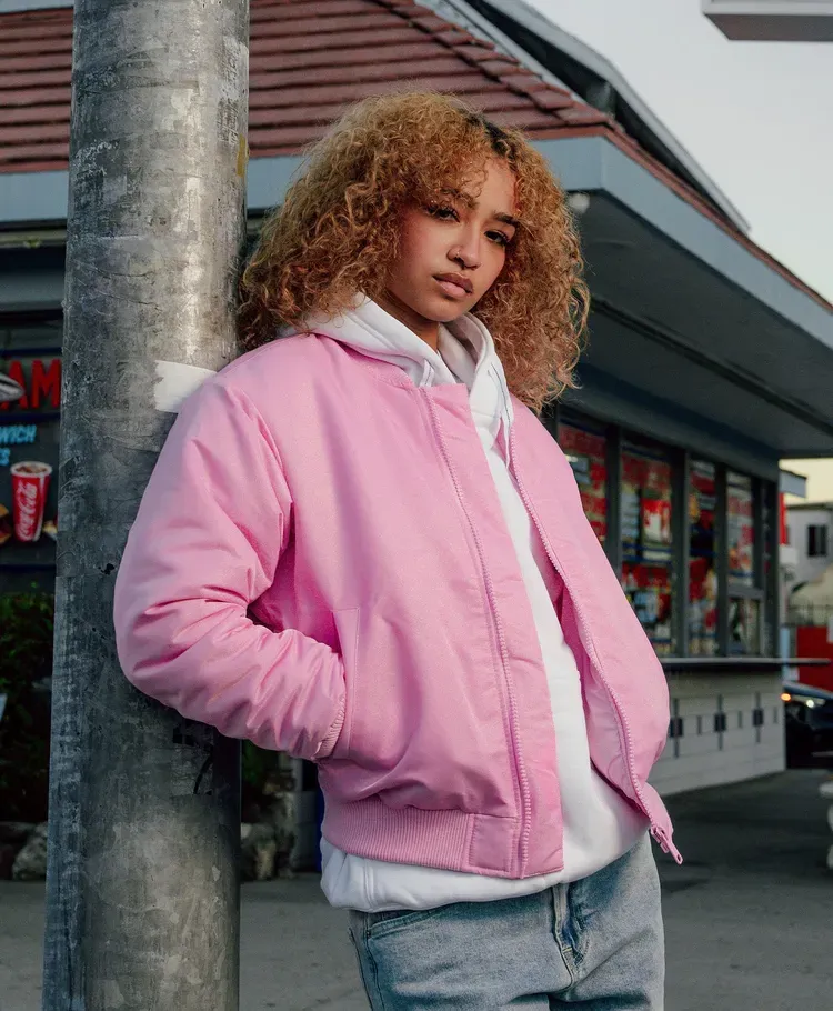 Woman in a pink puffer jacket - shop women's outerwear