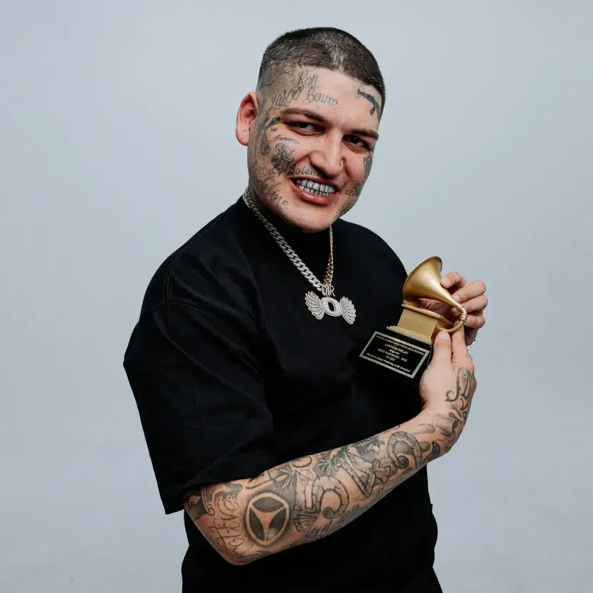 Lefty Gunplay in a black Pro Club tee holding a gold gramophone award
