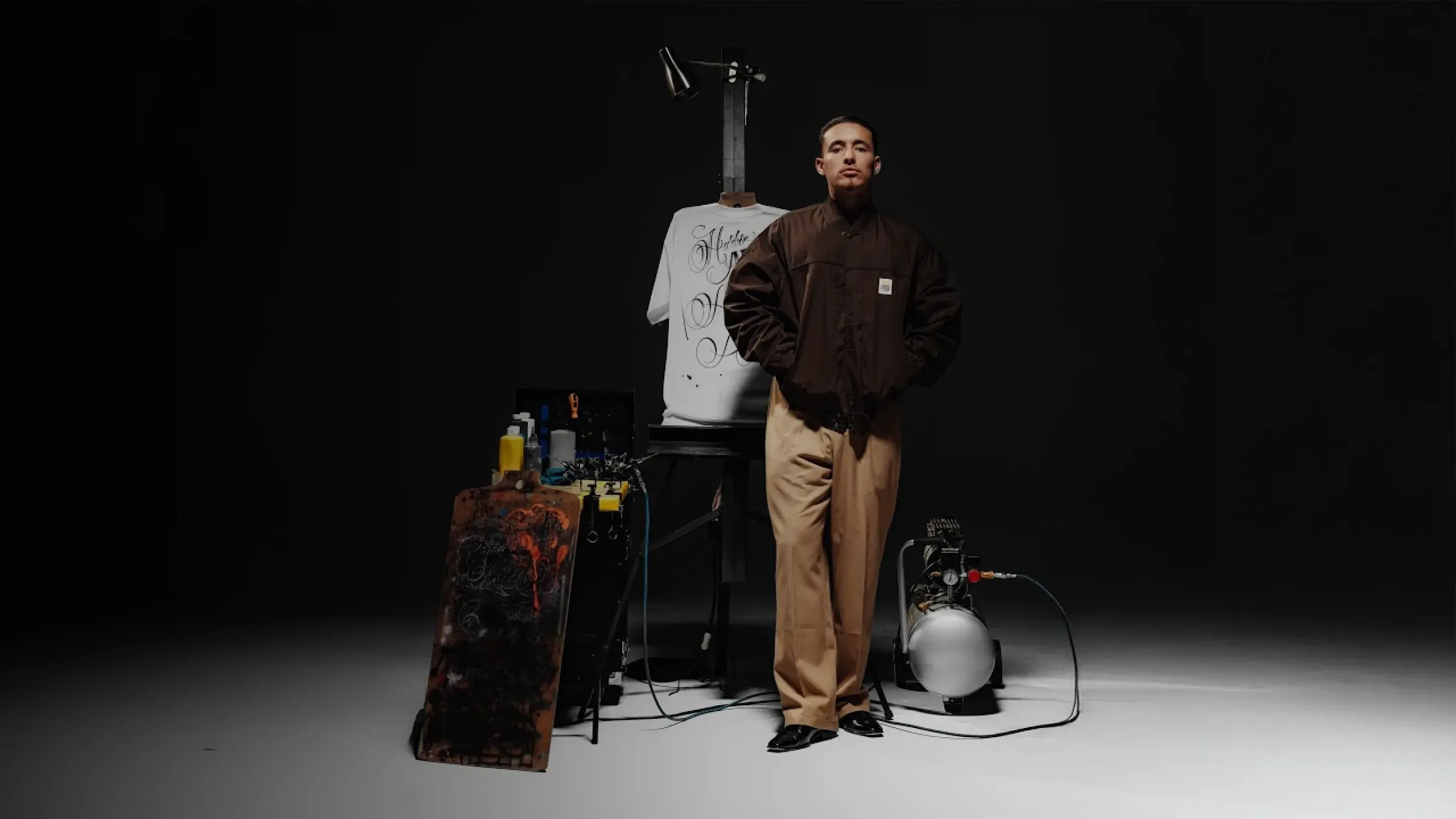 Mister Cartoon standing in a studio beside an airbrushed tee