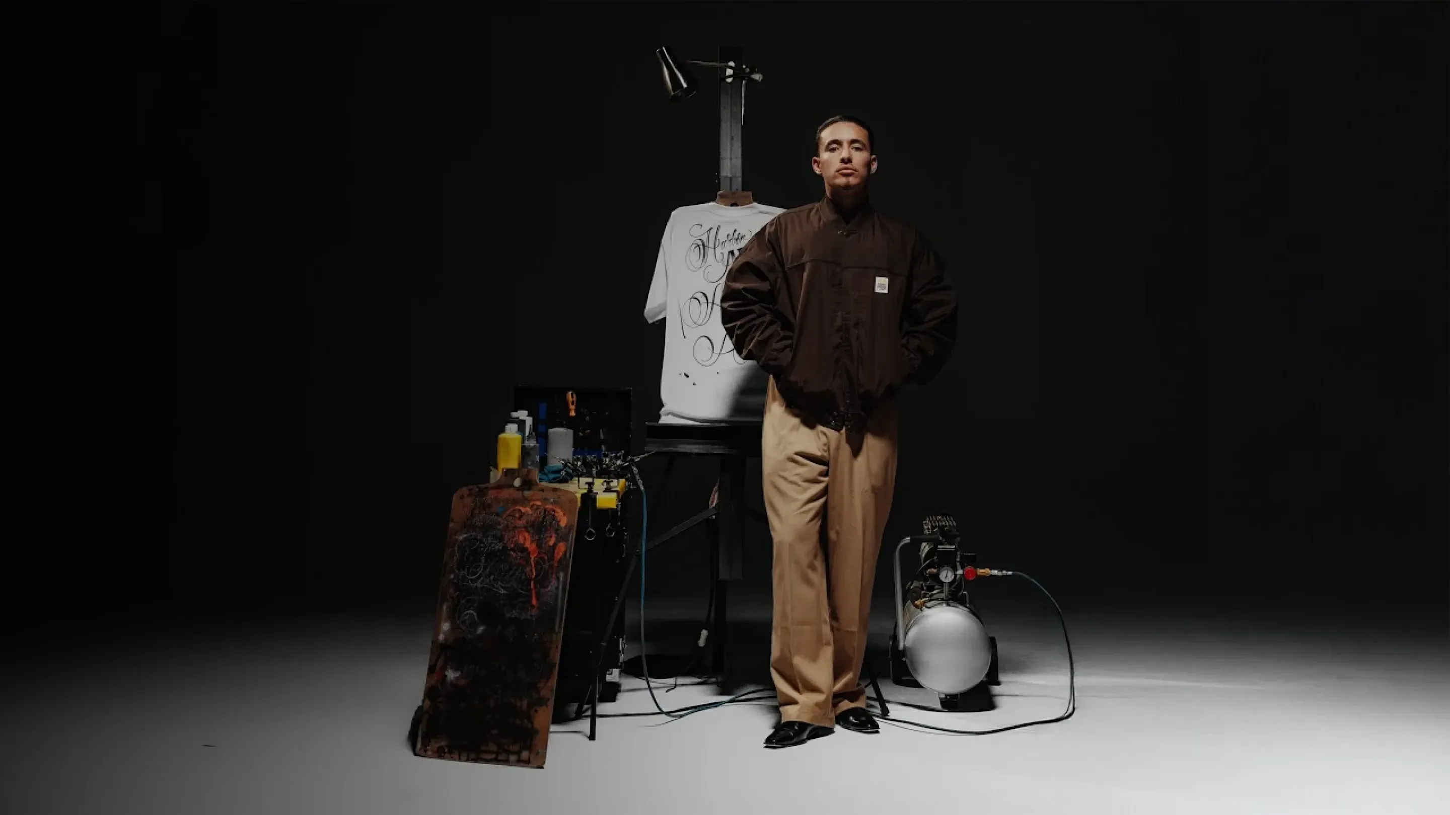 Mister Cartoon standing in a studio beside an airbrushed tee