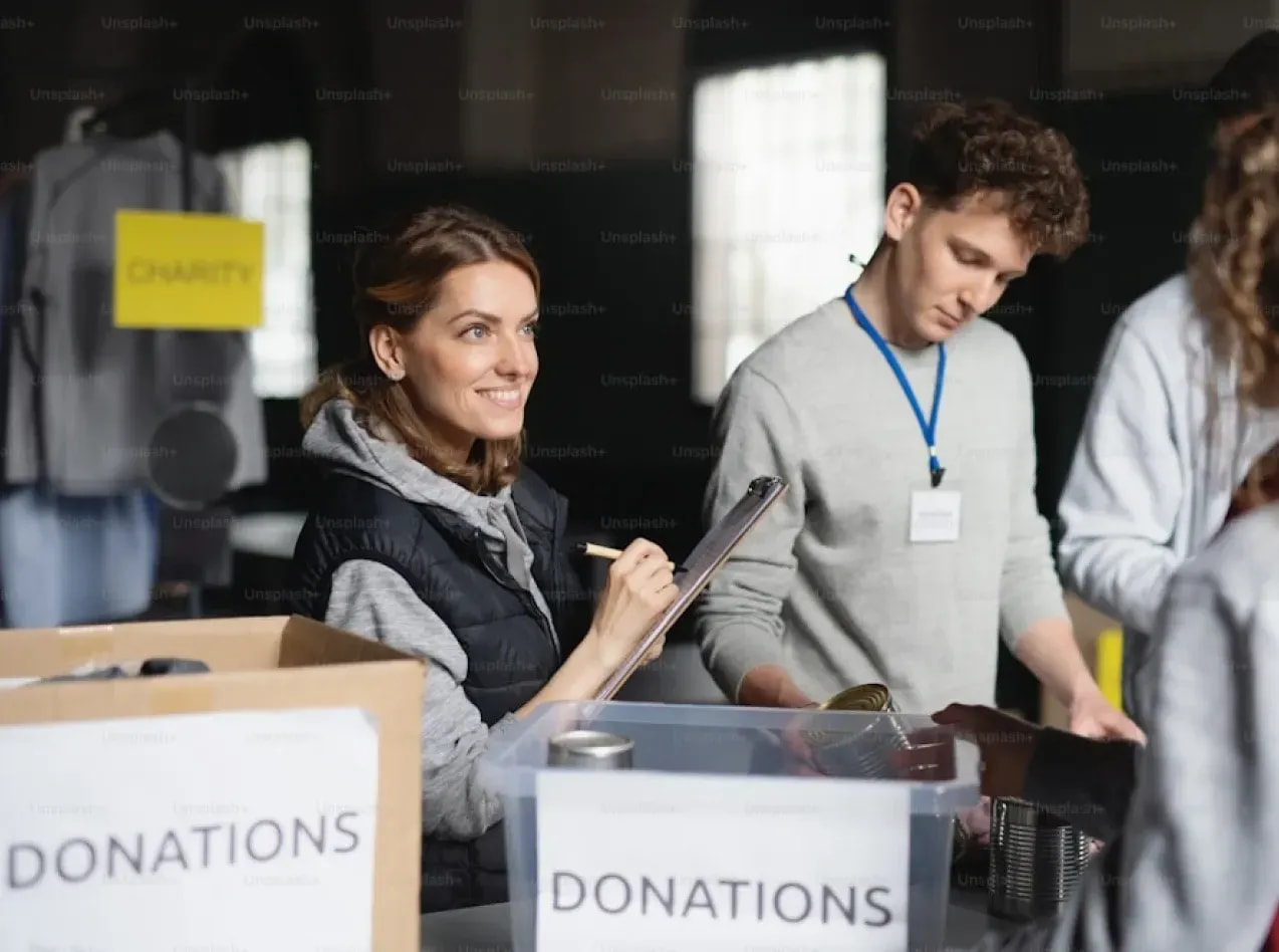 Volunteers sorting canned-food donations into boxes at a Pro Club giving drive