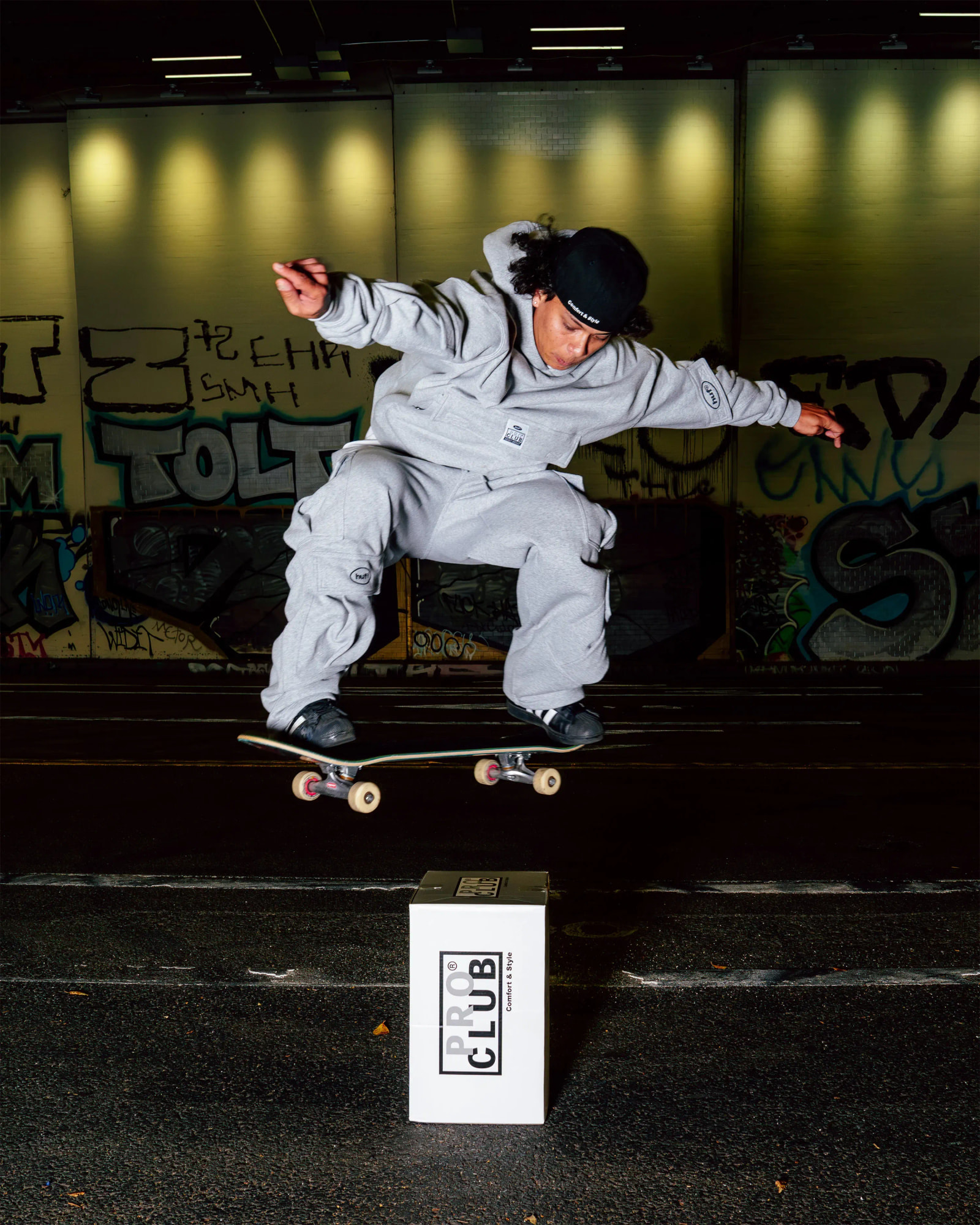 men in proclub X HUF tee & pant doing skates on proclub box