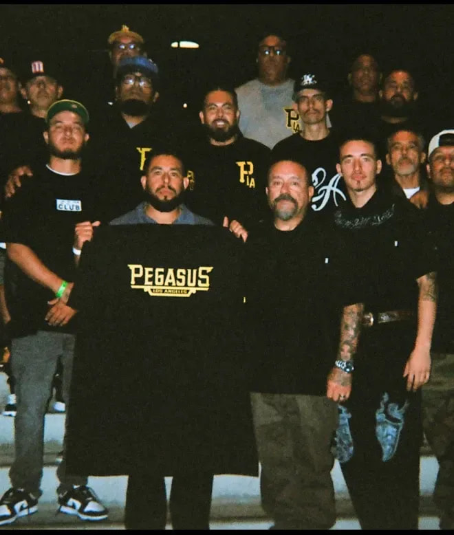 Man beside a white lowrider in a Pro Club pullover