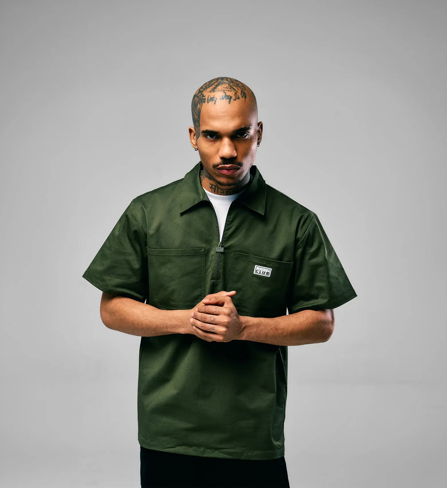 Man in a white Pro Club t-shirt and black cap holding a French bulldog - shop men's tops