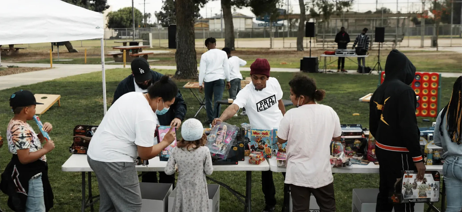 Volunteers handing out toys to kids at a Pro Club community day in an LA park