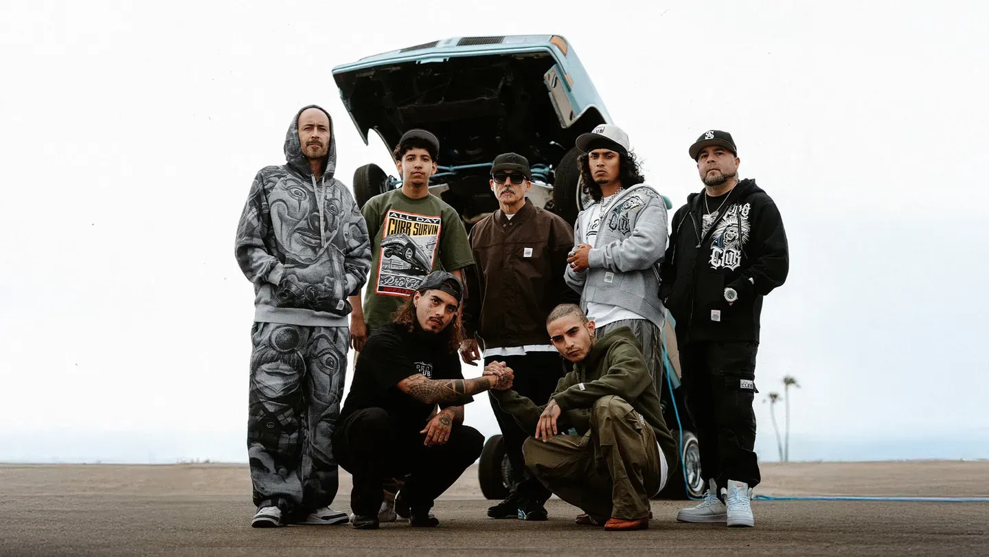 Group of collaborators by a lowrider — Pro Club exclusive collabs