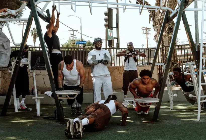 Men working out on outdoor gym equipment at a Pro Club community session